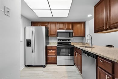Kitchen with light stone counters, stainless steel