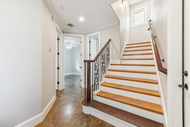 A bright entry with polished wooden stairs featuri