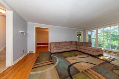 The spacious Living Room with large rear window offers a serene and panoramic view of the rear wooded garden
