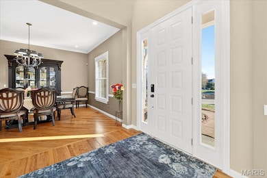 Foyer entrance with a chandelier, light wood finished floors, recessed lighting, and crown molding