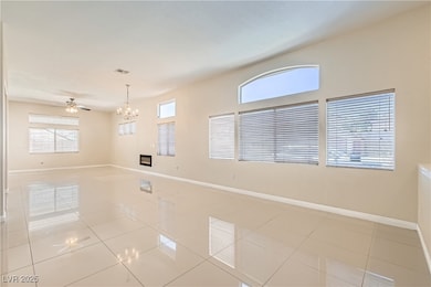 Tiled spare room with ceiling fan with notable cha