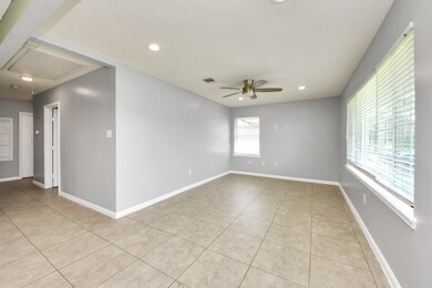 The living area features a ceiling fan, recessed l