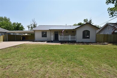 Single story home featuring a front yard, a carpor