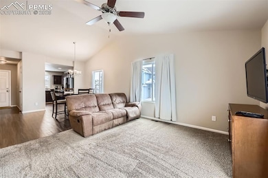 Living area with carpet flooring, vaulted ceiling,