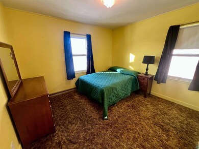 Carpeted bedroom with baseboard heating
