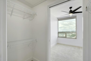 Walk in closet featuring ceiling fan and carpet