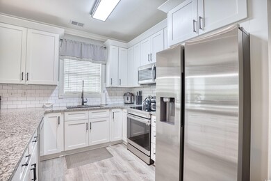 Kitchen featuring light wood-type flooring, tastef