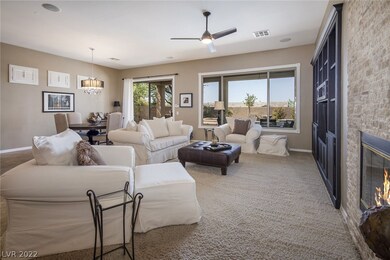 Looking towards rear yard in great room. Fireplace & built in wall unit add to beauty. Note stylish ceiling fan & surround sound speakers.