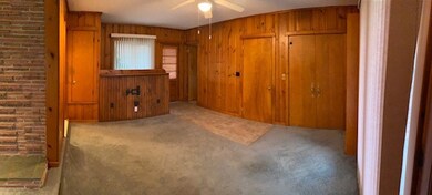 Den area with pine t&g walls.  Entrance to basemen