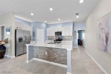 Kitchen with SS appliances, island with sink, whit