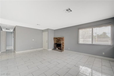 Unfurnished living room with light marble finish floors and a brick fireplace