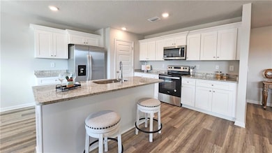 Kitchen with wood finished floors, a sink, a kitch