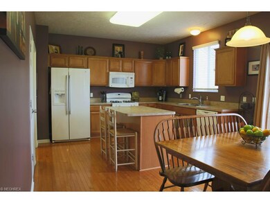 FULLY-EQUIPPED kitchen with hardwood floors, center island, family-sized dinette & access to patio.