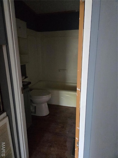 Bathroom featuring dark wood finished floors, shower / washtub combination, and vanity