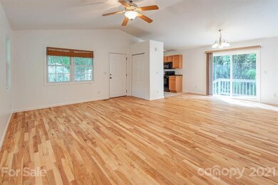 Vaulted ceilings highlight the openness and space of the open-concept living, dining, and kitchen area. The hardwood floors have been re-finished and there is fresh paint throughout.