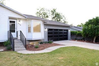 View of front facade with driveway, an attached garage, entry steps, and a front lawn