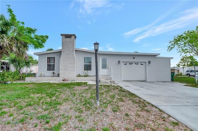 View of front facade featuring an attached garage, concrete driveway, and a chimney