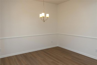 Empty room with dark wood-type flooring, baseboard