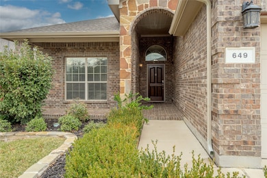 View of exterior entry featuring brick siding and roof with shingles