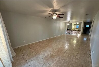 Unfurnished room featuring a ceiling fan, baseboards, and tile patterned flooring
