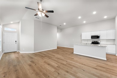 Unfurnished living room featuring a sink, baseboa