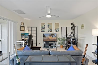 Living room featuring ceiling fan and light tile p