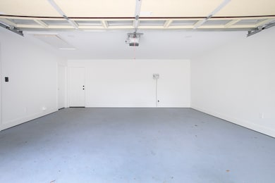 Garage with baseboards and a garage door opener