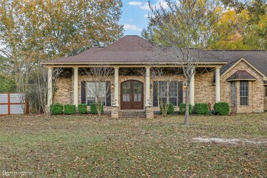 Greek revival inspired property featuring a porch, brick siding, french doors, and roof with shingles