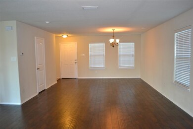 Unfurnished room with a notable chandelier and dark hardwood / wood-style floors