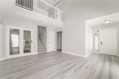 Unfurnished living room with stairway, light wood