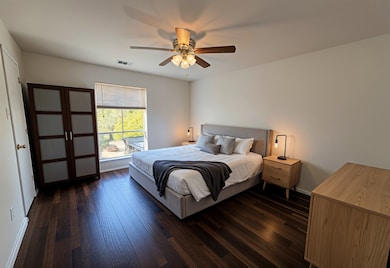Bedroom featuring dark wood-type flooring and ceiling fan