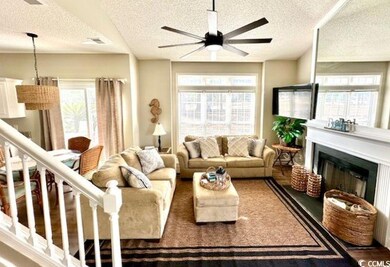 Living room with a fireplace, a textured ceiling, 