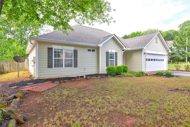 Single story home with fence, driveway, roof with 