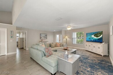 Living area featuring a ceiling fan and baseboards