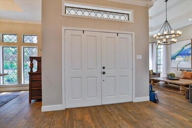 Entryway with a notable chandelier, dark wood-type