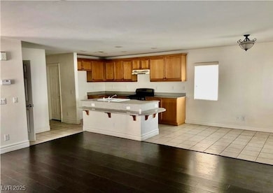 Kitchen with black range with electric stovetop, l