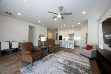 Living room featuring a ceiling fan and wood fini