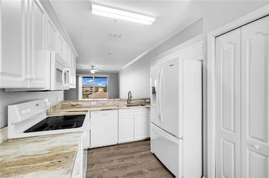 Kitchen with white appliances, a sink, white cabin