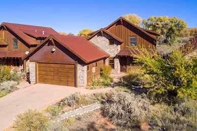 View of front of property featuring stone siding, driveway, board and batten siding, and an attached garage