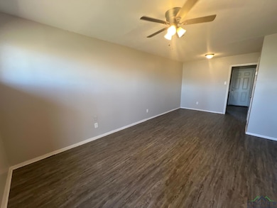 Unfurnished room with dark wood-style flooring, a 