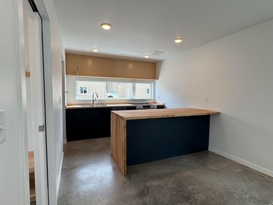 Kitchen featuring wood counters, dark cabinets, a peninsula, and recessed lighting