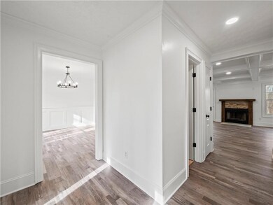 Hallway featuring coffered ceiling, crown molding,