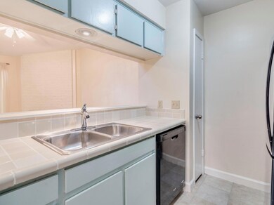 Kitchen featuring tile countertops, dishwashing m
