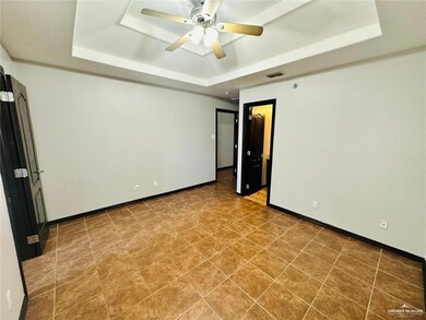 Unfurnished room with baseboards, ceiling fan, a tray ceiling, and visible vents