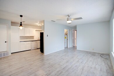 Unfurnished living room featuring ceiling fan, electric water heater, a textured ceiling, and light hardwood / wood-style floors