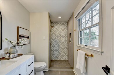 Full bathroom with vanity, tiled shower, recessed lighting, and tile patterned flooring