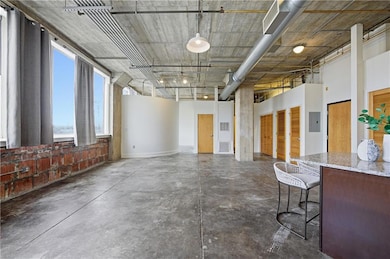 Miscellaneous room featuring concrete floors, electric panel, and a towering ceiling