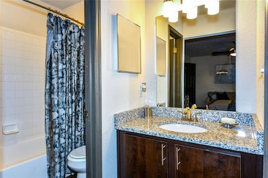 Full bathroom with vanity, toilet, ceiling fan, an