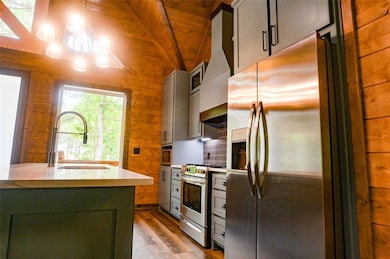 Kitchen featuring lofted ceiling, sink, wooden cei