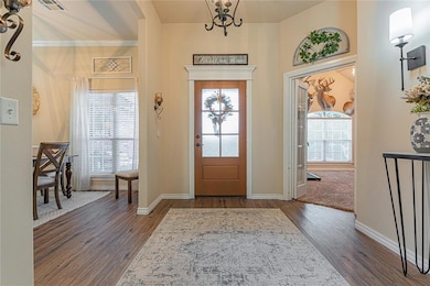 Foyer entrance featuring dark wood-style flooring and a chandelier
